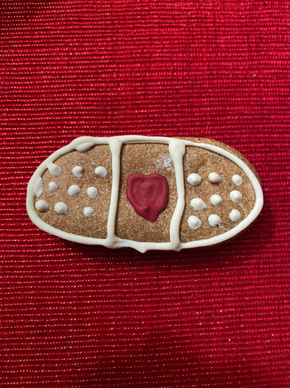 Organic peanut butter dog cookie shaped like a bandage from Get Well Organic Dog Cookie Box on red background