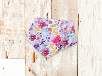 Lilac Watercolor Dog Bandana with floral print and adjustable snaps on wooden background