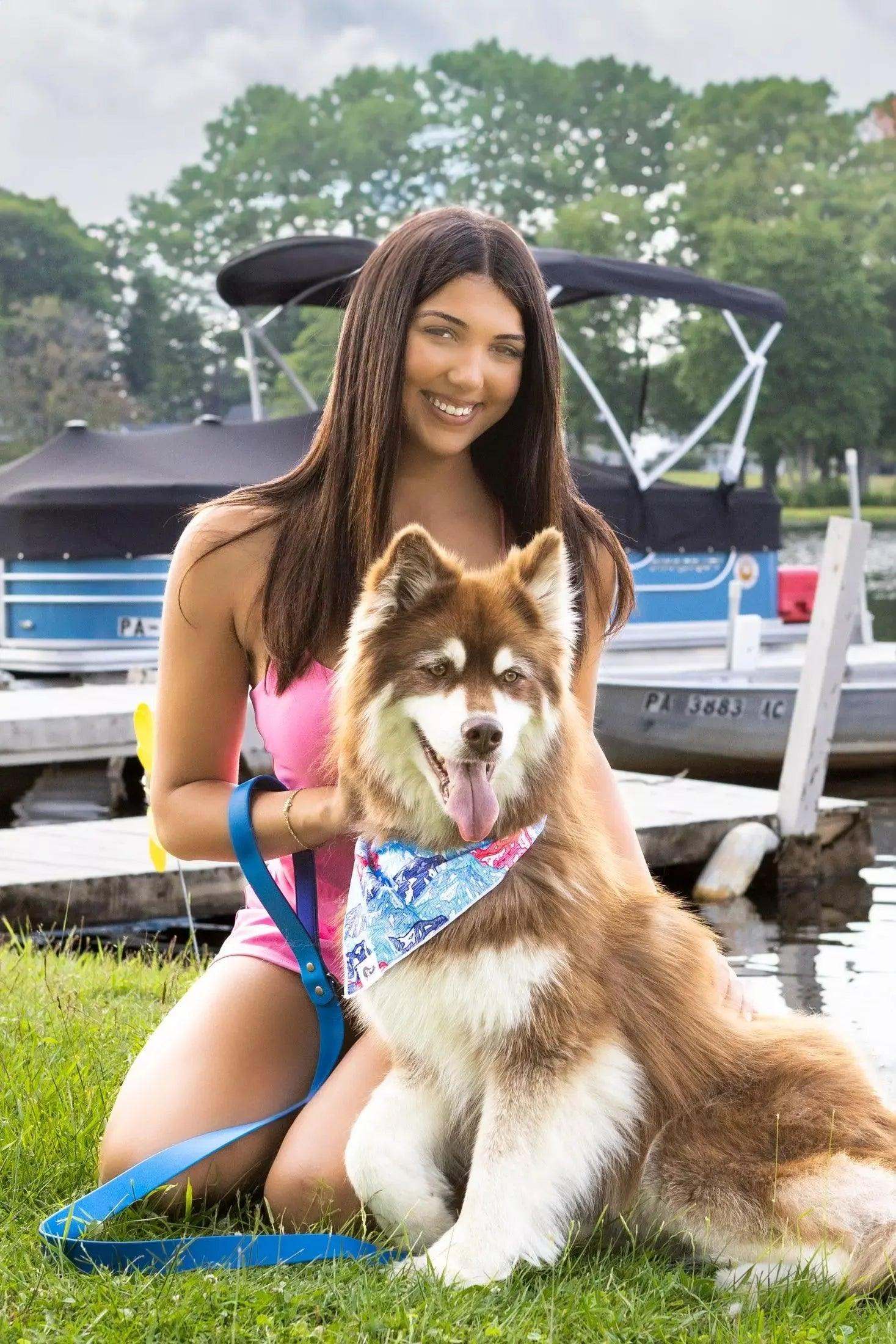 Painted Peaks Dog Bandana on a happy dog outdoors by the water with a woman in the background