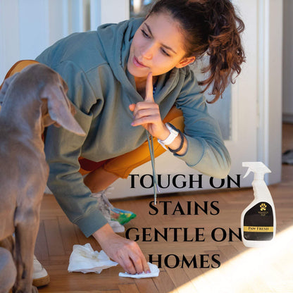 Woman cleaning pet stain on wooden floor with Paw Fresh spot cleaner and deodorizer spray bottle nearby