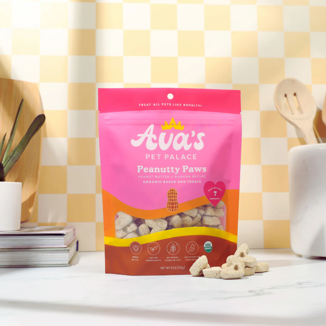 Ava's Pet Palace Organic Peanutty Paws dog treats in pink resealable bag with peanut-shaped crunchy treats displayed on kitchen countertop
