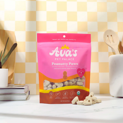 Ava's Pet Palace Organic Peanutty Paws dog treats in pink resealable bag with peanut-shaped crunchy treats displayed on kitchen countertop