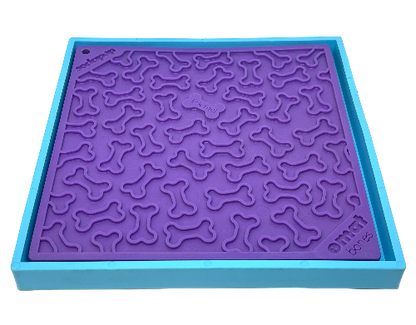 Hold 'em suction cup holder securing a purple dog lick mat with bone patterns on a blue frame