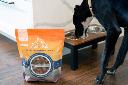 Premium raw freeze dried dog food beef package with black dog eating from bowl