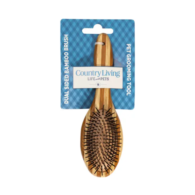 Country Living dual-sided natural wood dog brush with ergonomic handle and bristle and pin sides for grooming and detangling pets.