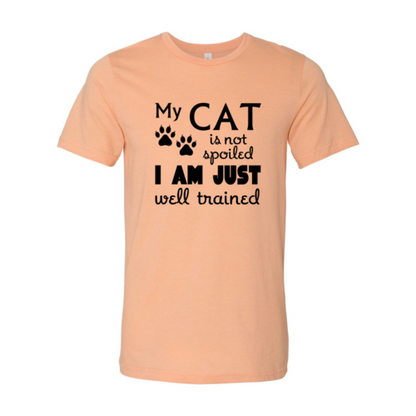My Cat Is Not Spoiled T-Shirt with black text and paw prints on peach Bella Canvas cotton tee
