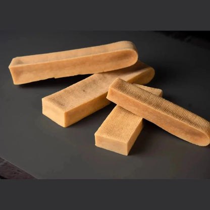 Yak Cheese Chews natural Himalayan dog treats in various sizes on black surface