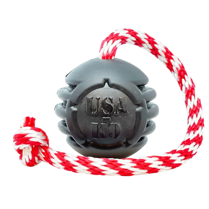 USA-K9 Magnum black rubber chew toy ball with red and white tug rope for durable dog play