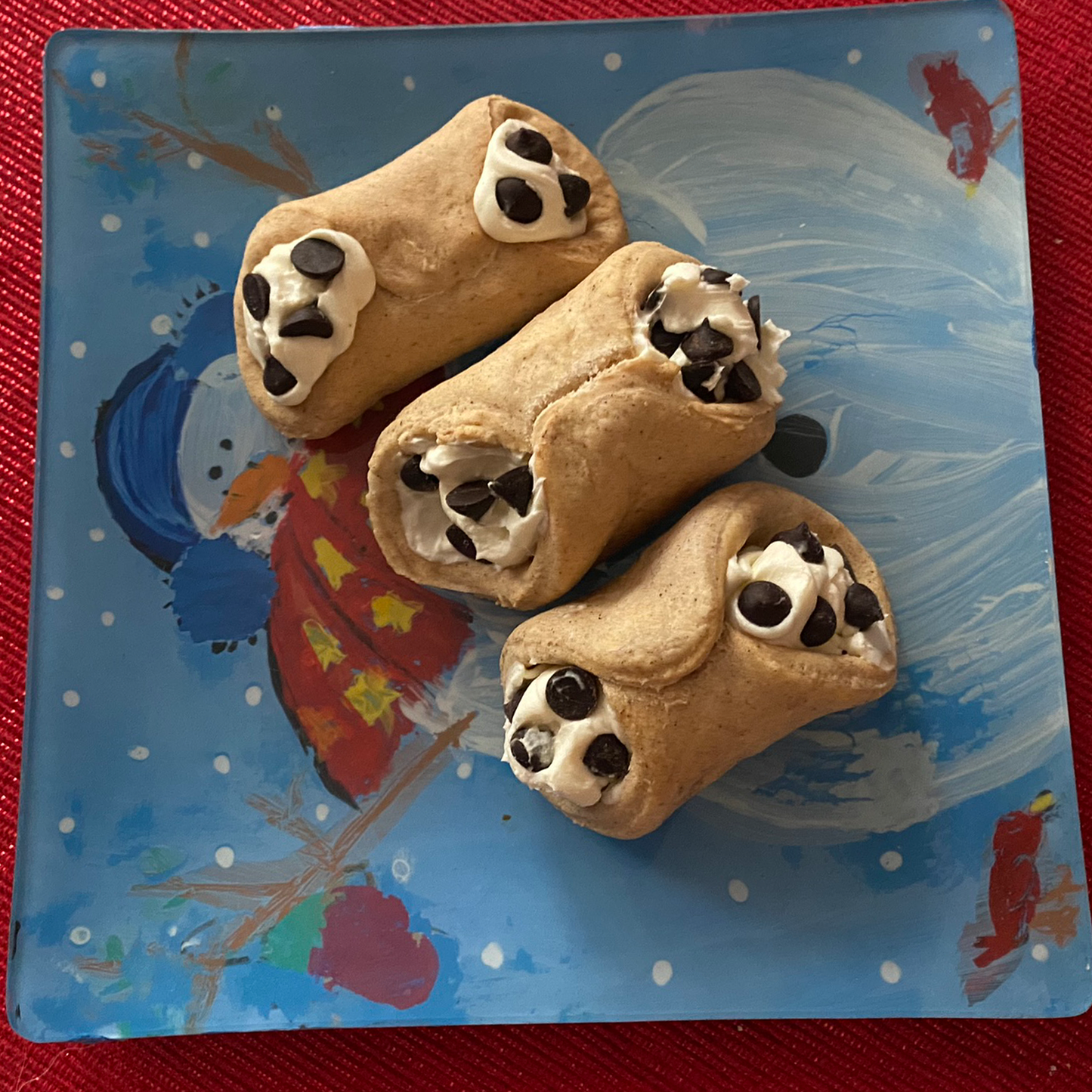 Organic cannoli-shaped dog treats with creamy filling and chocolate chips on a decorative plate