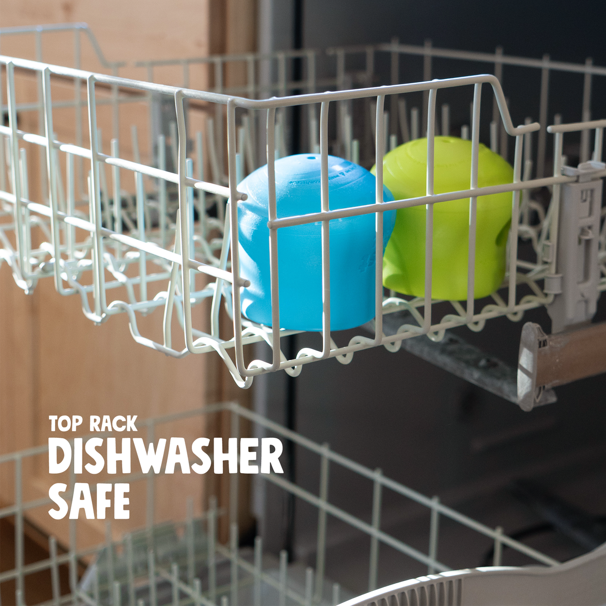 customizable puzzle and treat toy in blue and green made of durable rubber placed inside dishwasher rack for cleaning