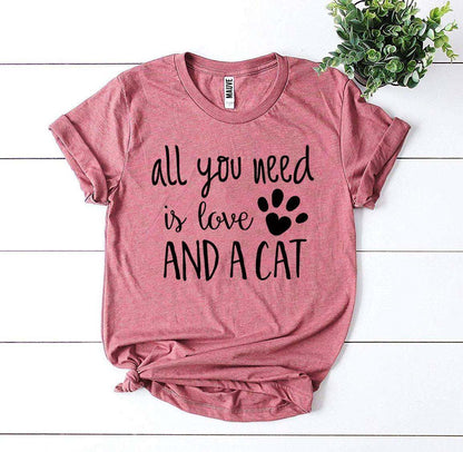 Pink Bella Canvas t-shirt with "All you need is love and a cat" black text and paw print design