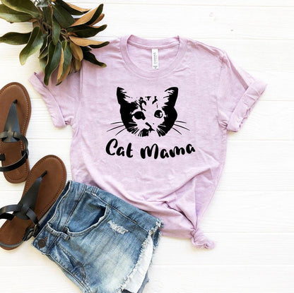 Light purple Cat Mama T-Shirt with black cat face graphic and text, paired with denim shorts and sandals on white background