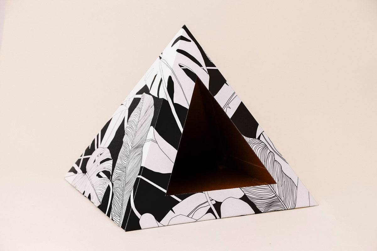 Dark Paradise Cardboard cat pyramid with black and white leaf design, cozy recycled cardboard hideaway for cats.