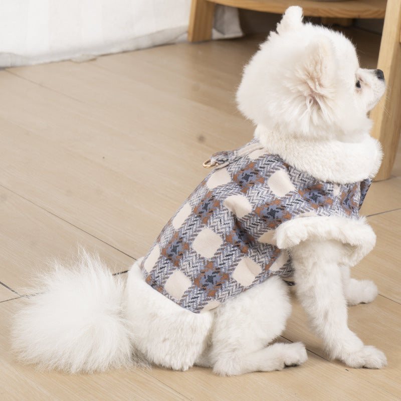 Small dog wearing a soft plaid vest with faux fur trim and collar, showcasing dog clothing with warmth for cold weather.