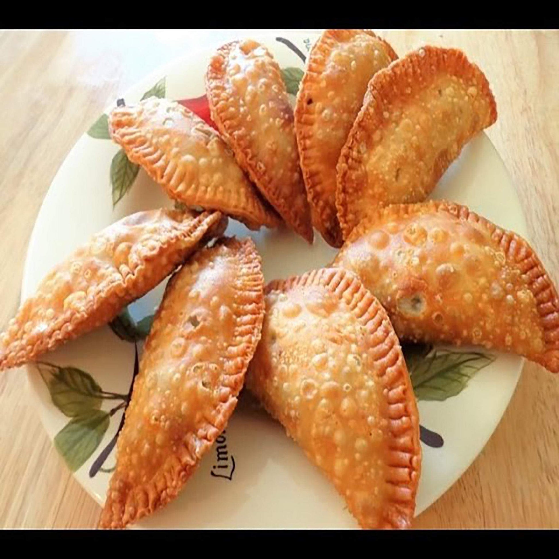 Plate of golden-brown organic beef EmPAWnadas with crispy pastry crust