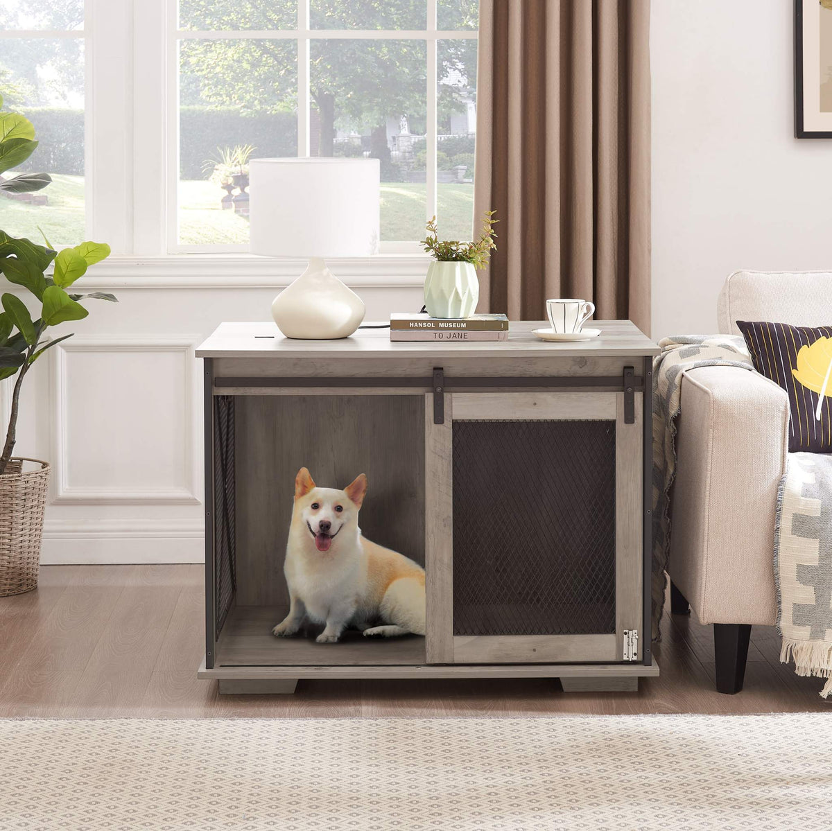 Farmhouse Barn-Door Dog Crate End Table in gray-wash wood with dark metal mesh panels and sliding barn door, holding a small dog