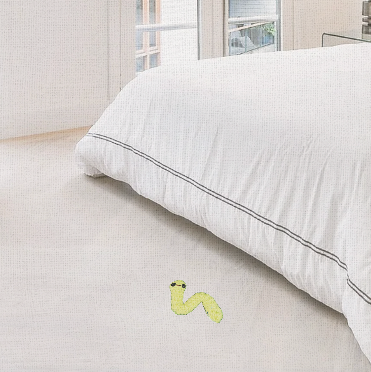 Noodle the Inchworm lightweight cat toy on bedroom floor near bed corner