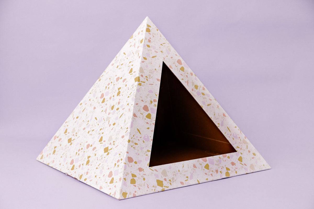 Terrazzo cardboard cat pyramid with triangular entrance on purple background