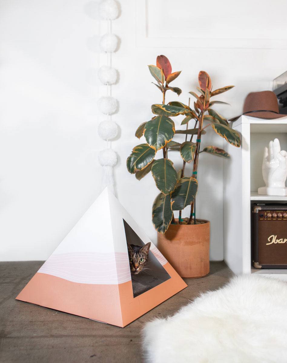 Wavey Cardboard Cat Pyramid with cat inside, modern pet hideaway made from recycled cardboard in stylish pink and white design