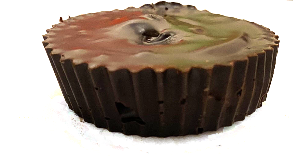 Organic peanut butter cup dog treat in a dark brown paper cup wrapper