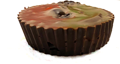 Organic peanut butter cup dog treat in a dark brown paper cup wrapper