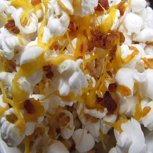 Close-up of bacon popcorn dog treats with cheese and bacon bits sprinkled on white popcorn