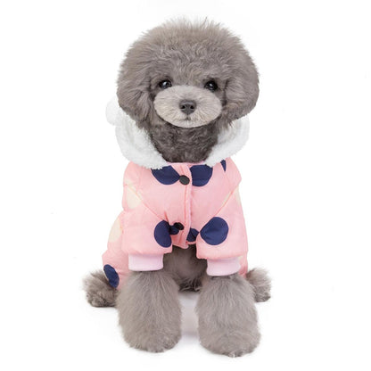 Small dog wearing pink waterproof dog snowsuit jumpsuit with big navy polka dots and fleece-lined hood