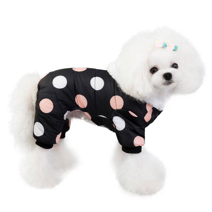 Small dog wearing waterproof black snowsuit jumpsuit with large pink and white polka dots and fleece lining for winter warmth