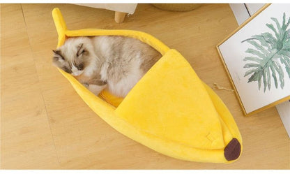 Cozy yellow banana-shaped pet bed with a fluffy cat inside on wooden floor