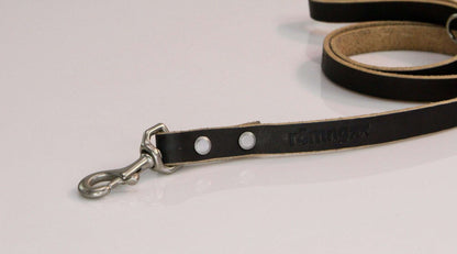 Black handmade leather dog leash with metal swivel clasp and rivets on white background