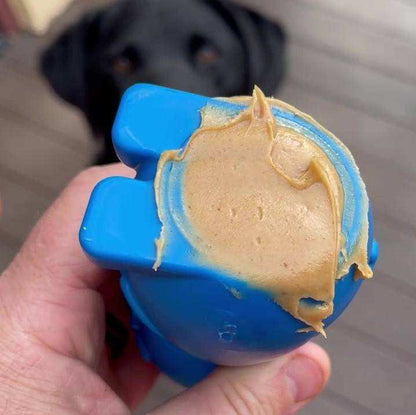Blue Bunny Nylon Chew Toy with peanut butter for aggressive chewers and a black dog in the background